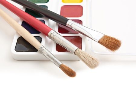 watercolor paints and  brushes isolated on a white  backgroundの写真素材