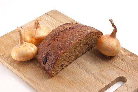 rye bread and onions on a cutting board isolated on whiteの写真素材