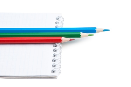 red  green blue pencils and notebook isolated on a white  backgroundの写真素材