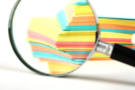 magnifying glass and a stack of paper for notesの写真素材