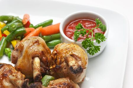 dishes of roast meat with vegetables and spices  isolated on white backgroundの写真素材