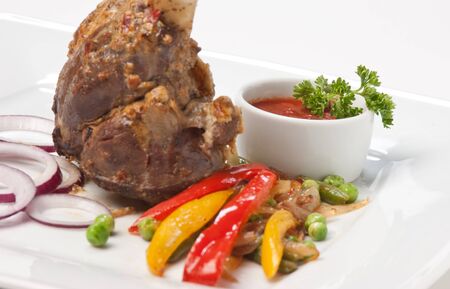 dishes of roast meat with vegetables and spicesの写真素材