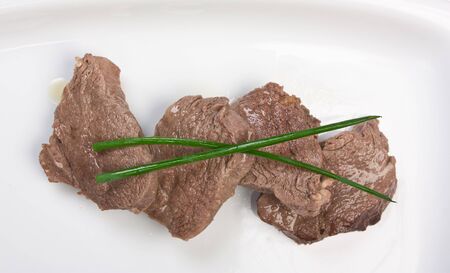 dishes of roast meat with vegetables and spicesの写真素材