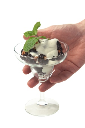 ice cream with prunes and walnuts in hand  isolated on whiteの写真素材