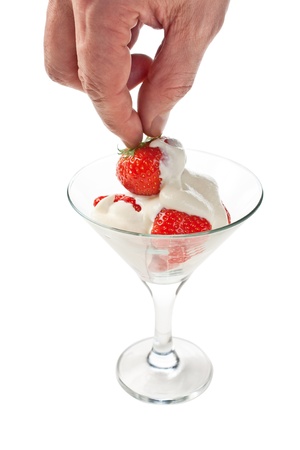 Ice cream with strawberries in hand  isolated on whiteの写真素材