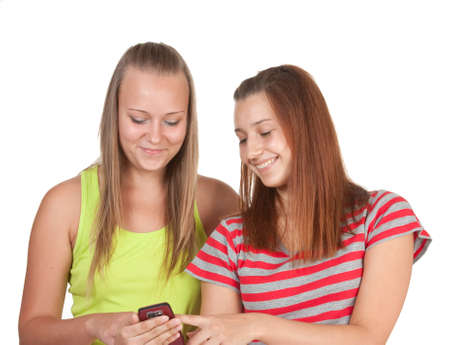 Portrait of lovely young women using mobile phone together  isolated on whiteの写真素材