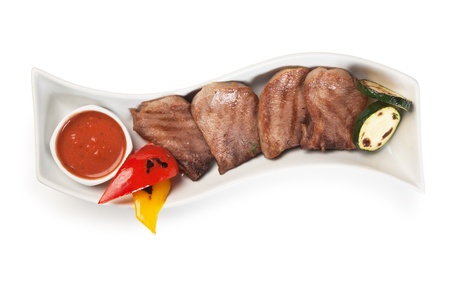 dishes of roast meat with vegetables and spices  isolated on white backgroundの写真素材