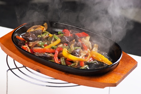 grilled meat with mushrooms and vegetables in a boiling panの写真素材