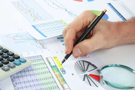 pen in hand and working paper chartの写真素材