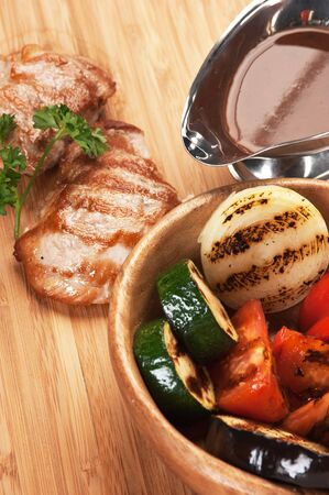 dishes of roast meat with vegetables and spicesの写真素材