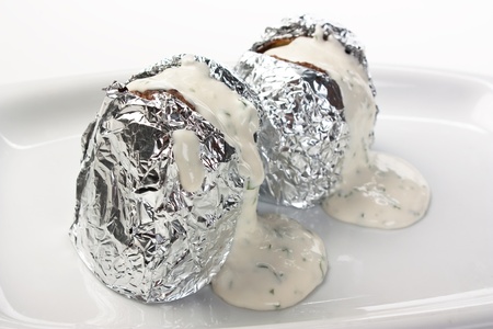 Stuffed potatoes in foil with spicesの写真素材