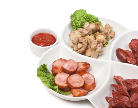 chopped sausages fried with vegetables and spices  isolated on white backgroundの写真素材