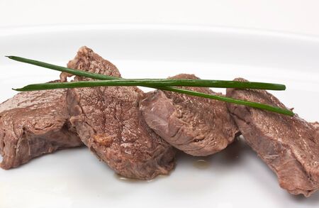 dishes of roast meat with vegetables and spicesの写真素材