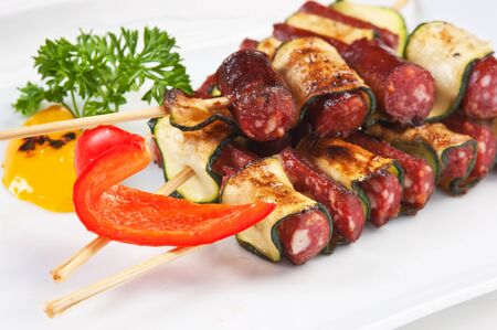 chopped sausages fried with vegetables and spices  isolated on white backgroundの写真素材