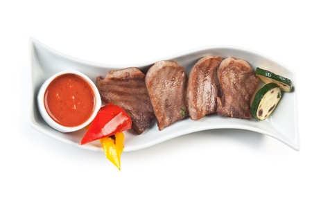 dishes of roast meat with vegetables and spices  isolated on white backgroundの写真素材