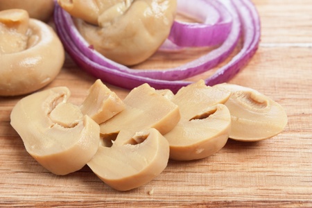 mushrooms and onions on a cutting boardの写真素材