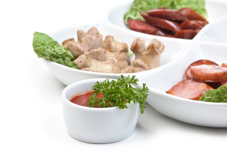 chopped sausages fried with vegetables and spices  isolated on white backgroundの写真素材