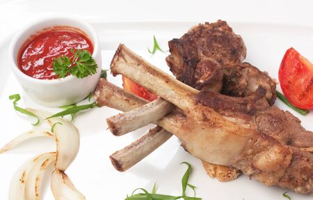 dishes of roast meat with vegetables and spicesの写真素材