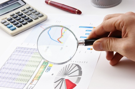 magnifying glass in hand and working paper chartの写真素材