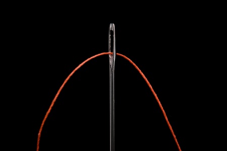 red thread in the eye of the needleの写真素材