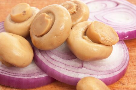 mushrooms and onions on a cutting boardの写真素材