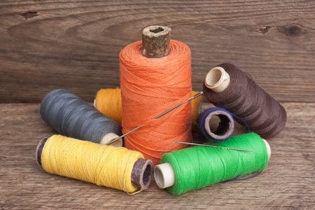 still life of spools of thread on a wooden background