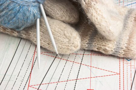 ball of yarn and mittens on a background pattern