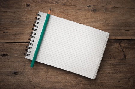 notebook and  pencil on a wooden background