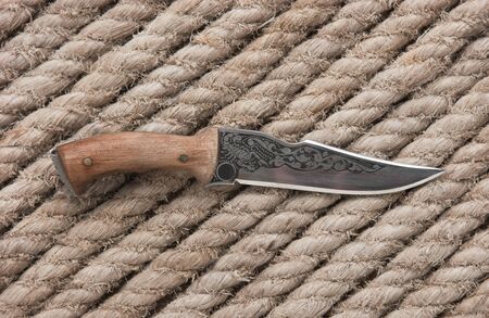 hunting knife on the background of hemp rope