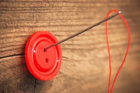 needle and a button on the board