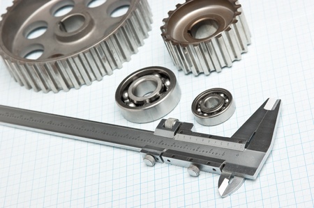 caliper with gears and bearings on graph paper