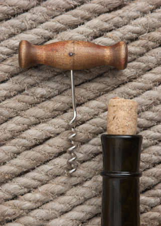 Old corkscrew and bottle of wineの写真素材