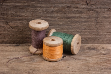still life of spools of thread on a wooden background