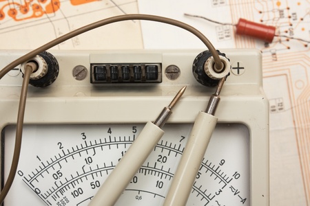 old analog multimeter and electronic component