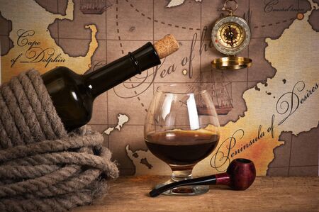bottle and  glass of wine on background of old maps