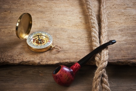 old tobacco pipe and compass on a wooden backgroundの写真素材