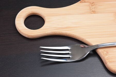 fork on a wooden cutting boardの写真素材