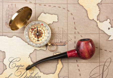 tobacco pipe and a compass on the mapの写真素材