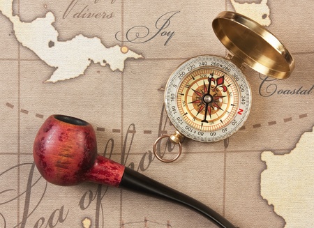 tobacco pipe and a compass on the mapの写真素材