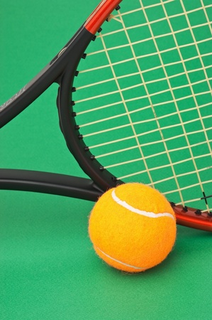 tennis racket and  ball on a green backgroundの写真素材