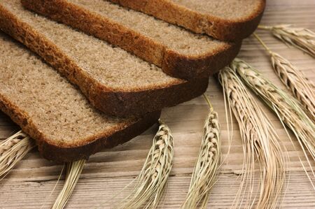 slices of rye bread and ears of corn on the wooden table