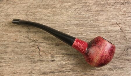 old tobacco pipe on a wooden backgroundの写真素材