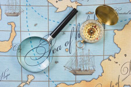 magnifier and compass on a stylized mapの写真素材