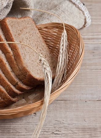 slices of rye bread and ears of corn in the basketの写真素材