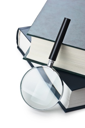  books and magnifying glass isolated on white backgroundの写真素材