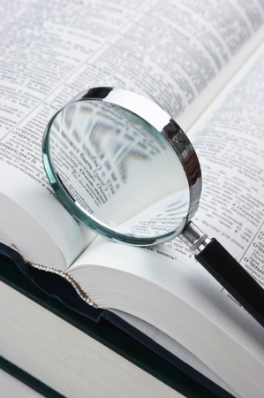  books and magnifying glass isolated on white backgroundの写真素材