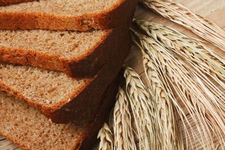 slices of rye bread and ears of corn on the wooden table