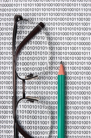 glasses and  pencil on the background of a binary codeの写真素材
