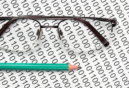 glasses and  pencil on the background of a binary code