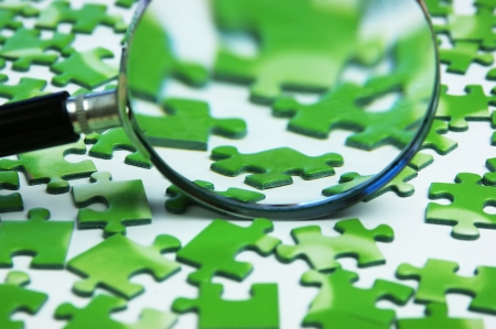 magnifying glass on the green puzzleの写真素材